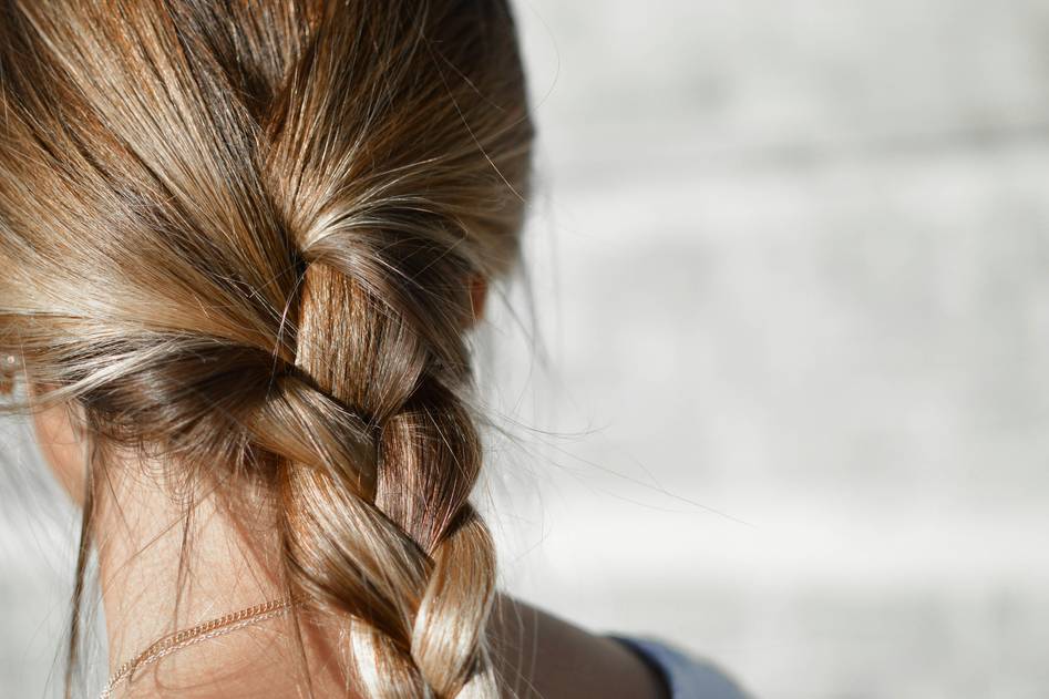 Close-up of elegant cornrow braids with golden accessories